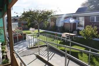 A lawn with table, chairs and an umbrella at Avon Lifecare
