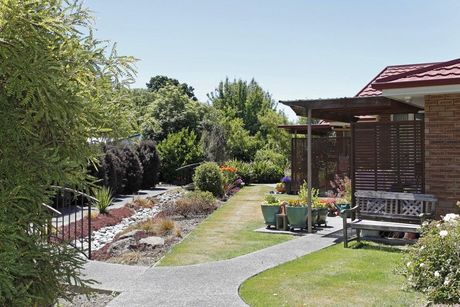 A Kauri Lodge villa with a path and bench at the front